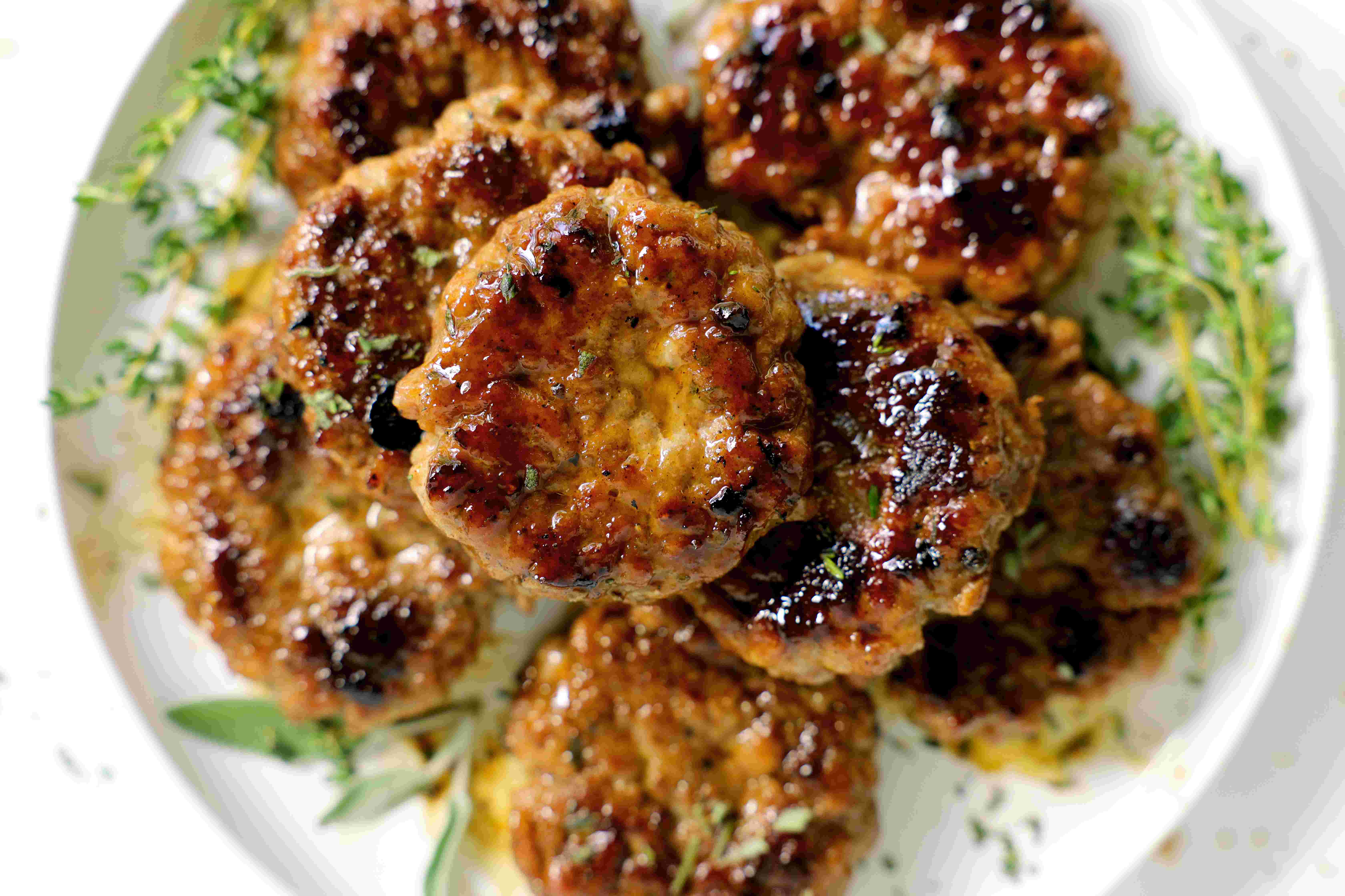 Prepared Breakfast Sausage Recipe on a white plate with fresh thyme