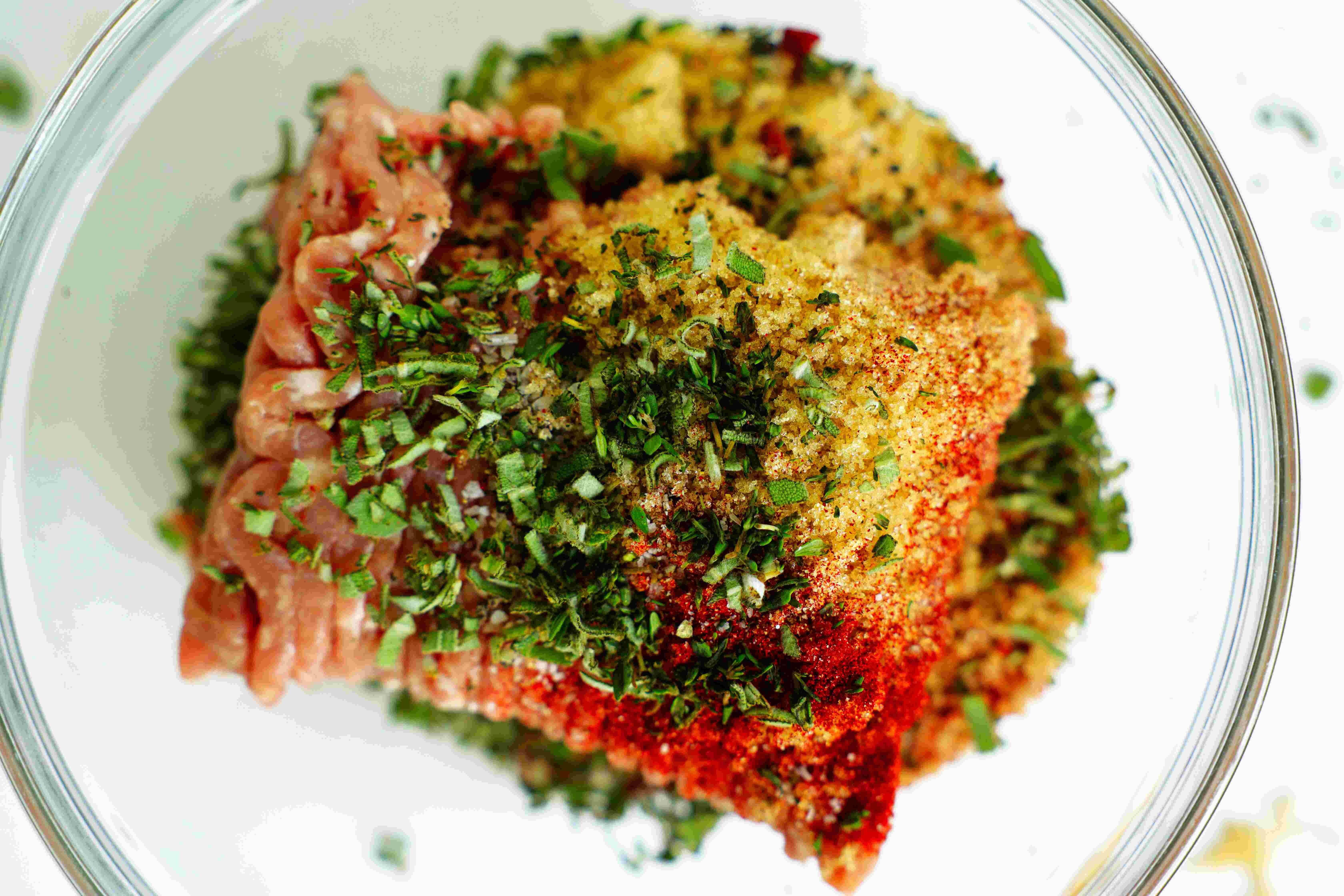 Uncooked pork in a bowl with dry ingredients for recipe