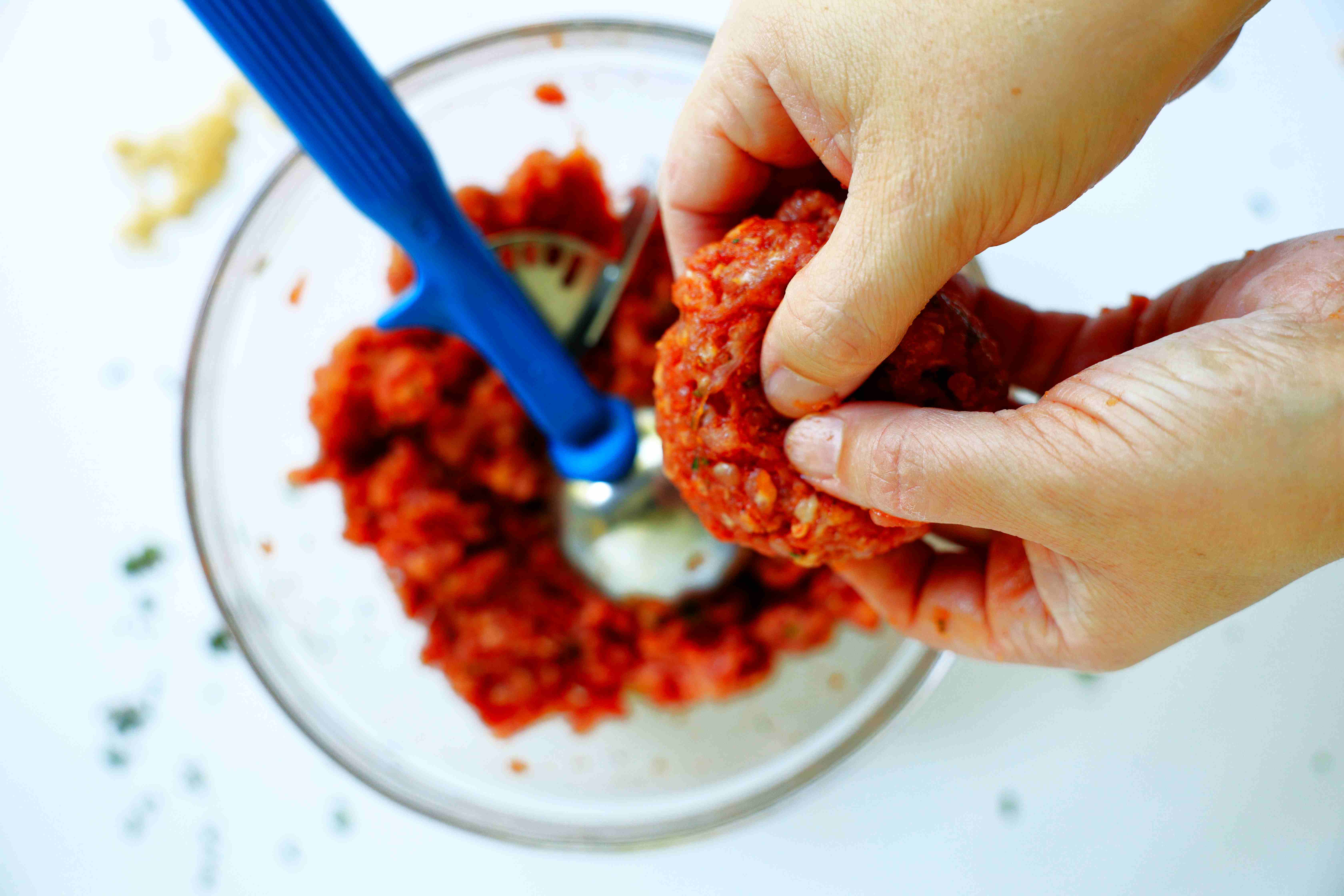 Uncooked breakfast sausage being formed into a patty