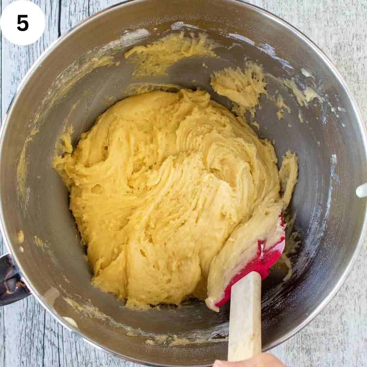 Spatula stirring thick cookie batter.