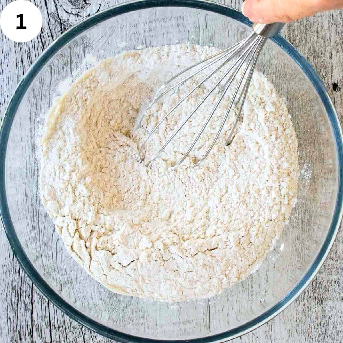 Whisking flour in a glass bowl.